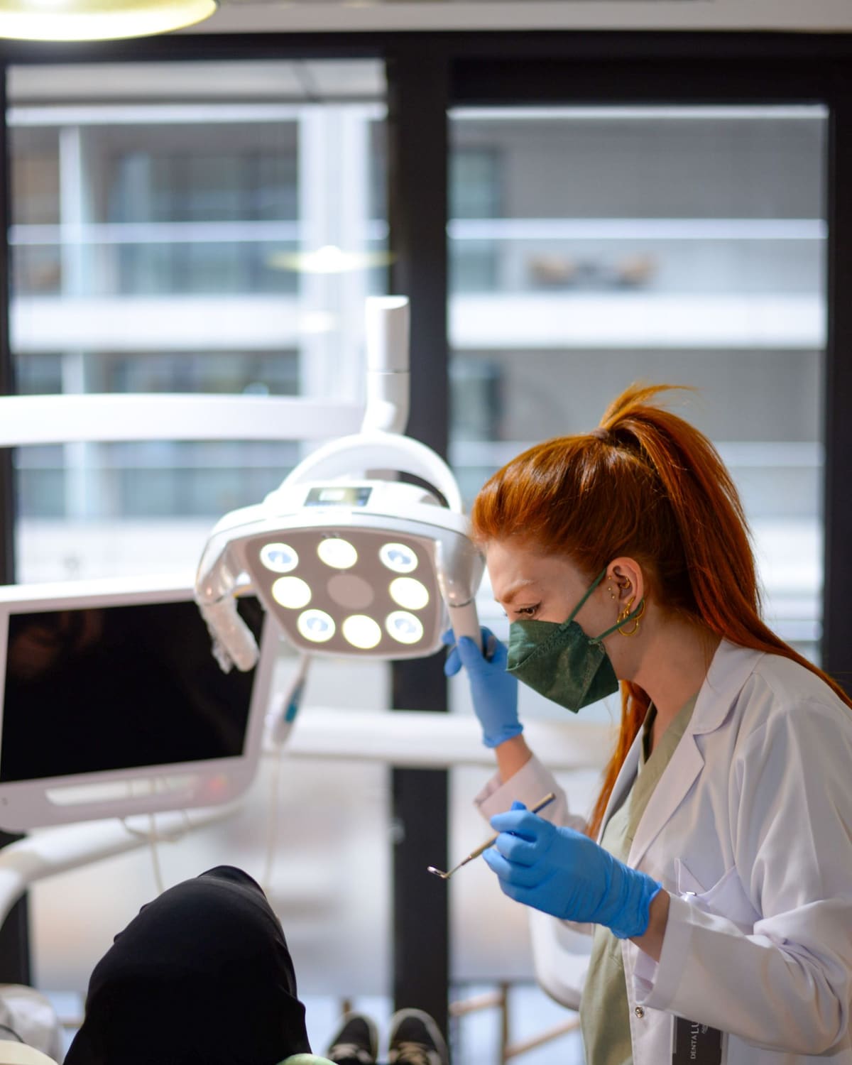 A dentist in mask and gloves working carefully on a patient