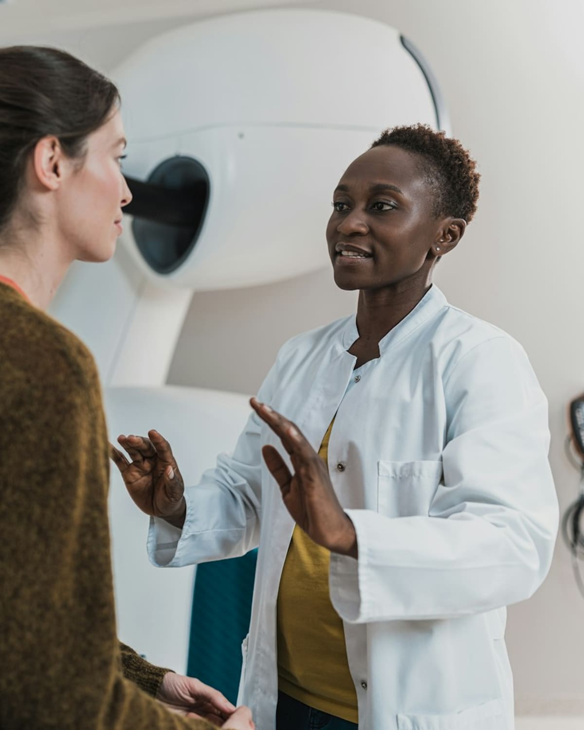 A doctor in a white coat explaining something warmly to a patient