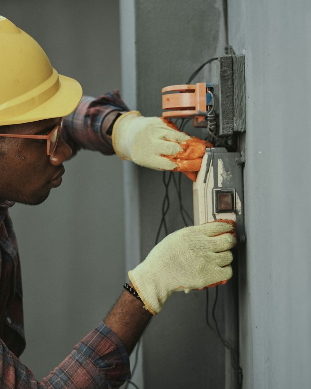 An electrician's hands wiring a panel