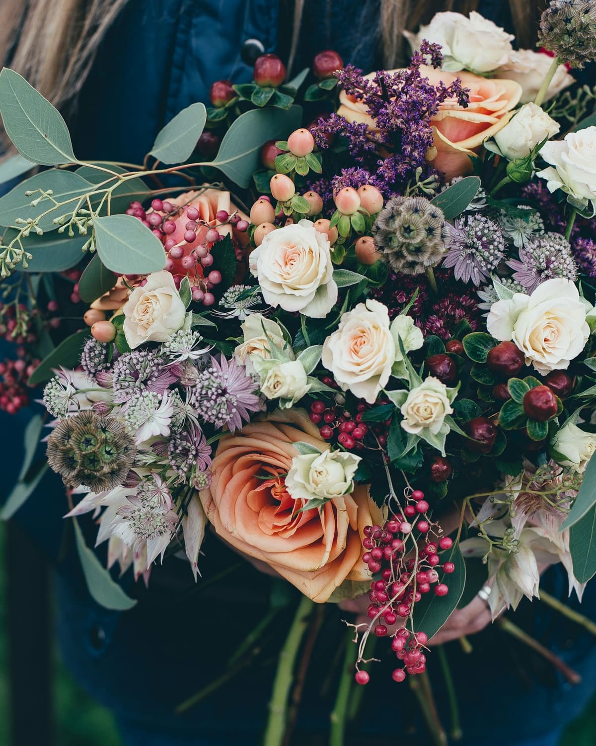 A florist holding a lush hand-tied bouquet