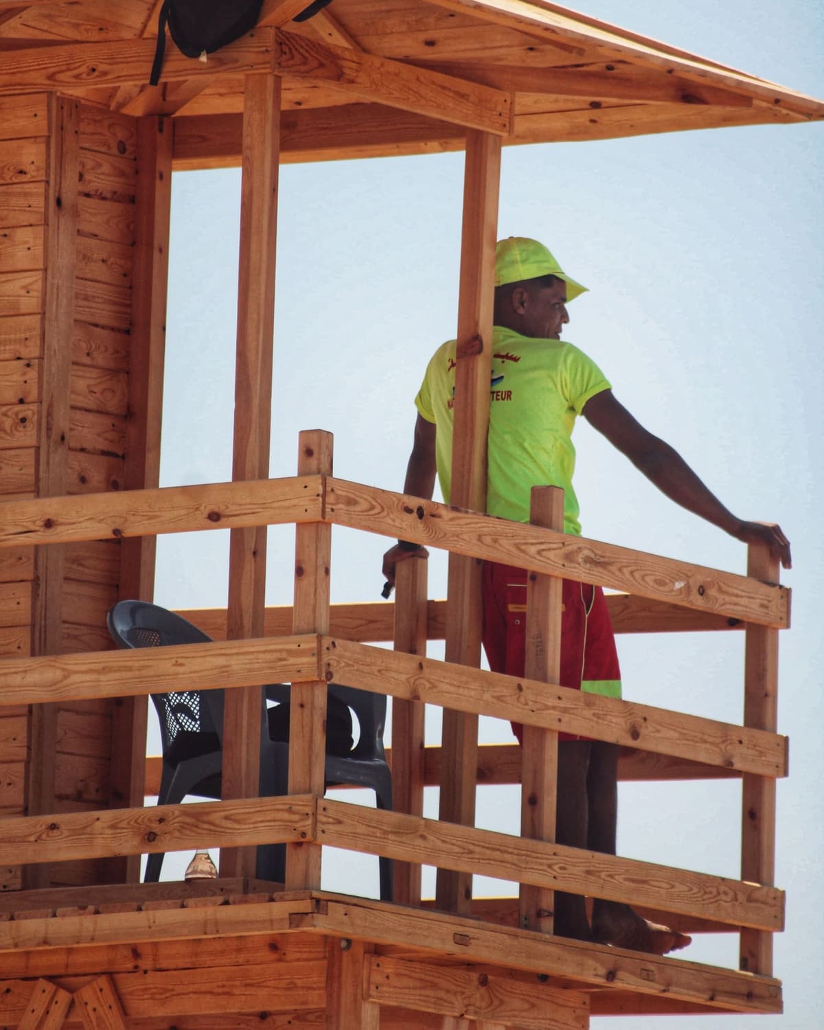 A lifeguard watching the sea from a wooden beach tower